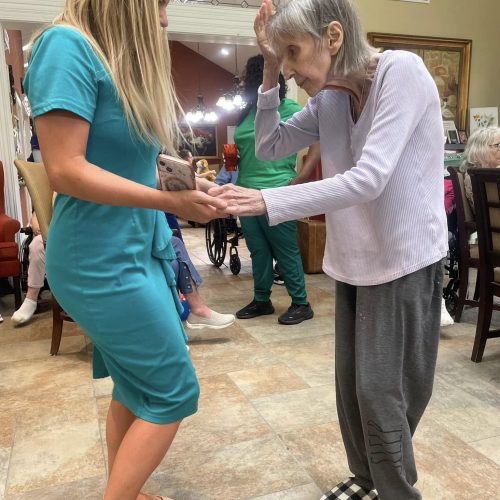 Caregiver and resident dancing at Dolan